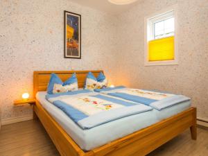奥斯特西巴德钦诺维茨Apartment Flaschenpost by Interhome的一间卧室配有一张带蓝色枕头的大型木制床。