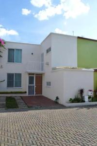 瓜达拉哈拉Preciosa y Cómoda Casa en Coto Tlaquepaque Centro.的前面有砖瓦车道的白色房子