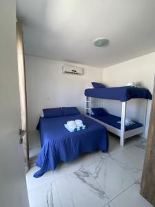 弗洛里亚诺波利斯Pousada da Mel - Canasvieiras Floripa的一间卧室配有蓝色的床和一张双层床。