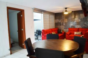 瓜达拉哈拉Preciosa y Cómoda Casa en Coto Tlaquepaque Centro.的客厅配有木桌和红色沙发