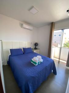 弗洛里亚诺波利斯Pousada da Mel - Canasvieiras Floripa的一间卧室配有蓝色的床,上面有两道菜