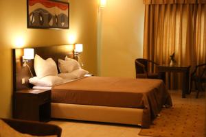 努瓦克肖特努瓦克肖特毛里中心酒店的配有白色枕头的床的酒店客房