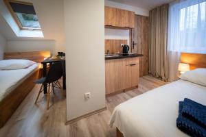 维斯瓦Pokoje Vik-House的酒店客房设有两张床、一张桌子和一间厨房。