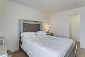 奥罗拉Spacious Home with Patio Near Denver Airport的白色卧室配有一张带白色床单的大床
