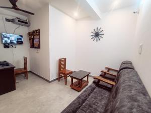 埃尔加德Skylight Residency Yercaud的客厅配有沙发和墙上的时钟