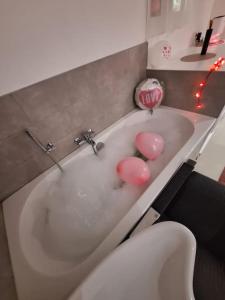 隆德泽尔Relax House B&B Londerzeel的浴室配有带粉红色球的浴缸。