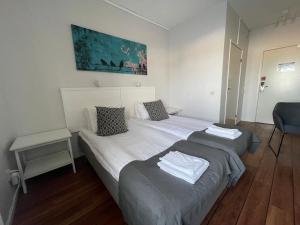 法尔雪平拉斯塔法尔柯平汽车旅馆的一间卧室配有两张床和一张蓝色椅子