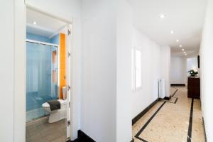 格拉纳达Neptuno Ático, con terraza的走廊上设有带淋浴和卫生间的浴室