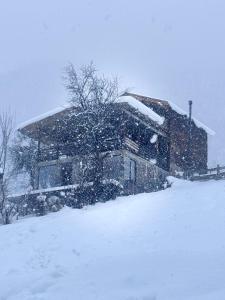梅斯蒂亚Villa Dabderr Mestia的前面的雪覆盖的房子