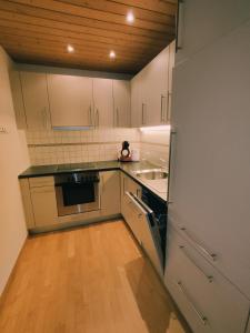 圣尼克劳斯Appartement in St. Niklaus的厨房铺有木地板,配有白色橱柜。