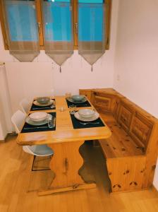 圣尼克劳斯Appartement in St. Niklaus的木桌,上面有盘子和碗
