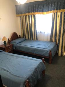 梅洛El Cortijo Apart - Hotel的一间卧室设有两张单人床和一个窗户。