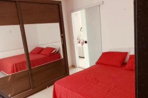 盖比姆Casa Ventos Guaibim的一间带镜子和红色床的卧室