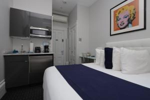 波士顿Charming & Stylish Studio on Beacon Hill #2的酒店客房带一张床和一个厨房