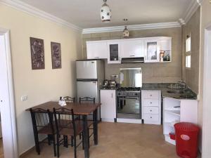 沙姆沙伊赫Serra Resort-Napa- Great Area的厨房配有白色家电和桌椅