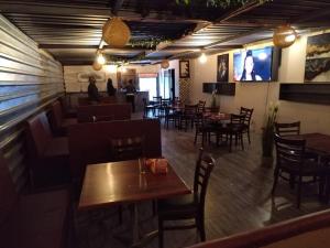 纽卡斯尔NN Jacaranda Guesthouse的一间带桌椅的餐厅和一间酒吧