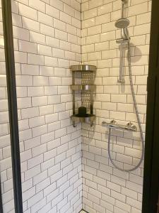 安特卫普Simone's Kitchen B&B的浴室内铺有白色瓷砖并配有软管的淋浴