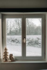 杜柏Villa ADurbuy avec Jacuzzi的窗户,有圣诞树和雪覆盖的田野