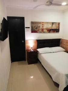 卡塔赫纳Apto amoblado barrio Los Alpes Cartagena的一间卧室设有两张床和一扇黑色的门
