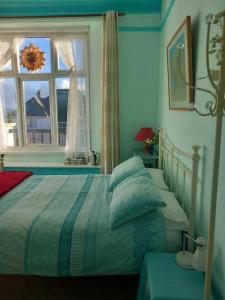 法尔茅斯Falmouth Lodge的卧室配有带枕头的床铺和窗户。
