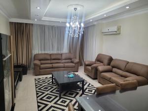 开罗Logistic Apartment的客厅配有两张沙发和一个吊灯。