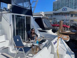 帕诺滩Delightful 2 Bdrm Sport Yacht with Pool的坐在船上桌子上的女人