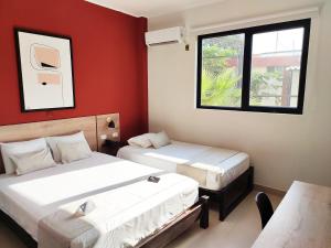 塔拉拉Rua Hoteles Talara的红色墙壁客房的两张床