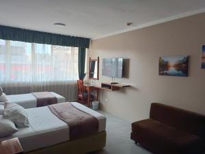 马查拉Grand Hotel Americano的酒店客房设有两张床和电视。