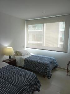 卡塔赫纳Cartagena Beach Condo - 1400 sq. Ft. (130 m2)的带窗户的客房内的两张床