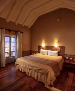 库斯科坦博德尔阿列罗精品酒店的一间卧室设有一张大床和一个窗户。