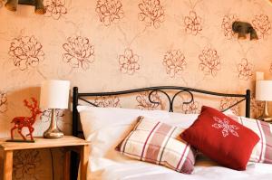 锡纳亚Cabana Stana Tarle的一间卧室配有红色和白色枕头的床
