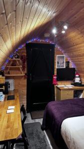 洛哈尔什教区凯尔高地Heatherbrae Cosy Wooden Pod的一间设有床铺、书桌和黑色门的房间