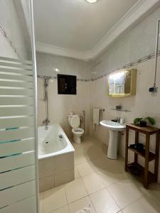 达喀尔Villa Jade的带浴缸、卫生间和盥洗盆的浴室