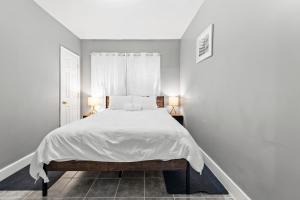 新贝德福德Vida Comfy Inn 3 bedroom Apartment 8 mins to downtown and ferry的白色卧室配有带两盏灯的白色床