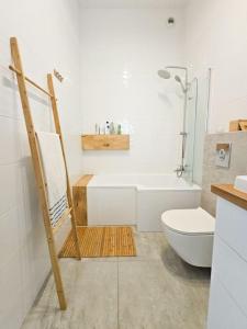 格但斯克Oasis Oliwa的带淋浴、卫生间和盥洗盆的浴室