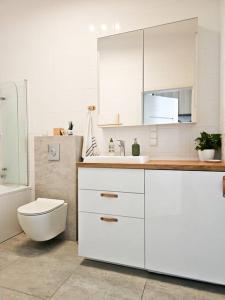 格但斯克Oasis Oliwa的白色的浴室设有卫生间和水槽。