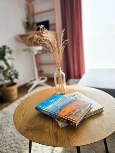 格但斯克Oasis Oliwa的一张桌子,上面有一本书和一个花瓶
