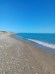 波利科罗Stella Marina Jonica 1km vom Strand mit Terrasse的晴天,海滩上拥有岩石和海洋