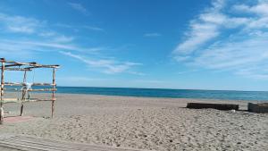 波利科罗Stella Marina Jonica 1km vom Strand mit Terrasse的海滩上的长凳