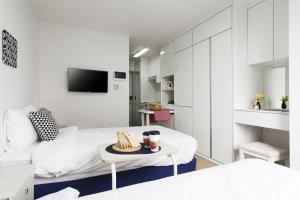 首尔清晨天空公寓的白色的客房配有一张床和一张桌子