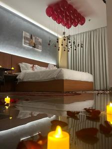 麦地那فندق كلاودز Clouds Hotel的一间卧室配有一张带红伞和蜡烛的床。