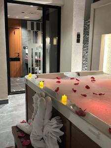 麦地那فندق كلاودز Clouds Hotel的柜台上的浴室,配有红色玫瑰花瓣