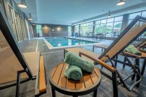 托莱多Courtyard by Marriott Toledo West的客房设有游泳池和带枕头的桌子