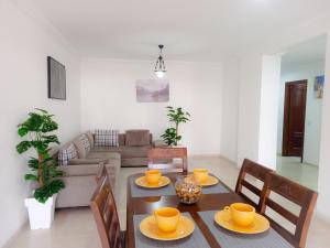 丹吉尔Appartement à MALABATA en face CENTRE COMMERCIAL MEGARAMA & la gare de TGV M2的一间带桌椅的用餐室和一间客厅