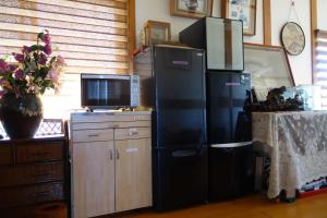 佐渡市Natural Mind Tour guest house - Vacation STAY 23292v的一间带大型黑色冰箱和电视的厨房