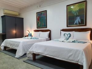 波尔多·格尼拉AV Suites的一间卧室配有两张带白色床单的床