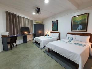 波尔多·格尼拉AV Suites的一间卧室配有两张床、一张桌子和一台电视。