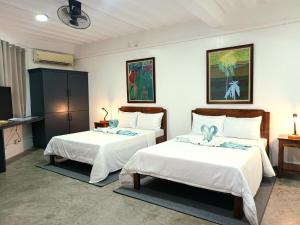 波尔多·格尼拉AV Suites的一间带两张床的卧室和一台电视