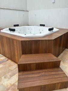 卡波布里奥Pousada Velas do Forte的浴缸位于木制平台上