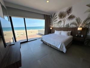坦皮科Soleare Hotel Boutique的一间卧室配有一张床,享有海滩美景